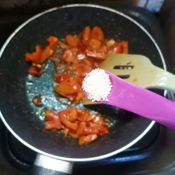 Masukkan tomat, aduk rata. Bumbui dengan garam dan kaldu jamur.