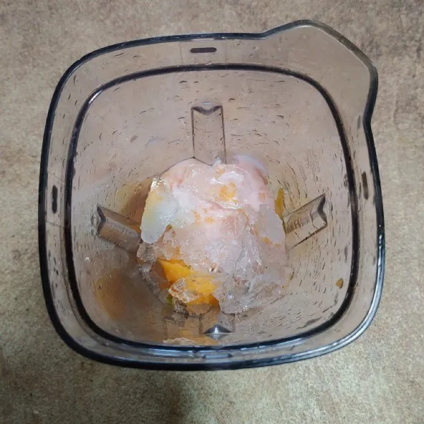 Masukkan mangga, yoghurt, madu dan es batu ke dalam blender.