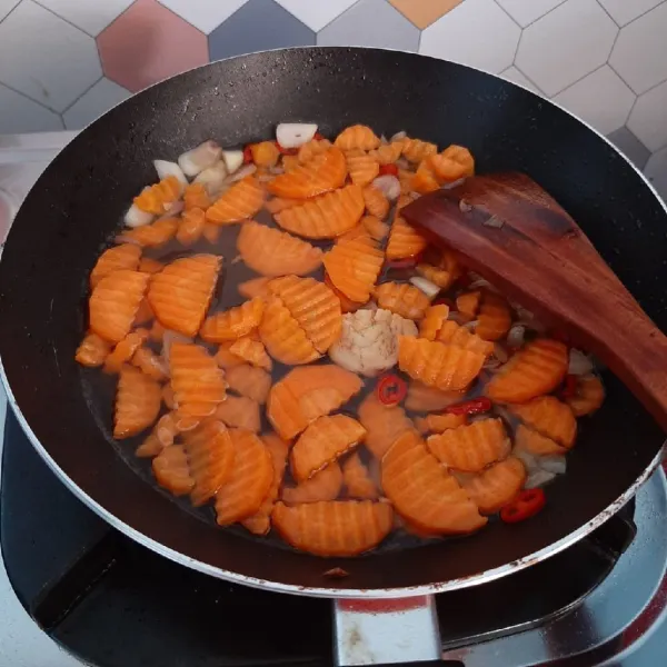 Tambahkan sedikit air, lalu masukkan wortel. Bumbui dengan garam, kaldu bubuk, lada dan saus tiram.