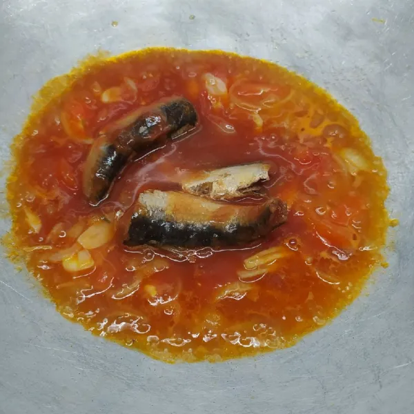 Tumis bawang bombay, bawang putih, dan irisan tomat sampai layu dan harum. Masukkan sarden, tambahkan air ½ tinggi kaleng sarden.