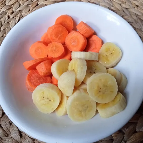 Kupas pisang dan wortel, lalu potong-potong.
