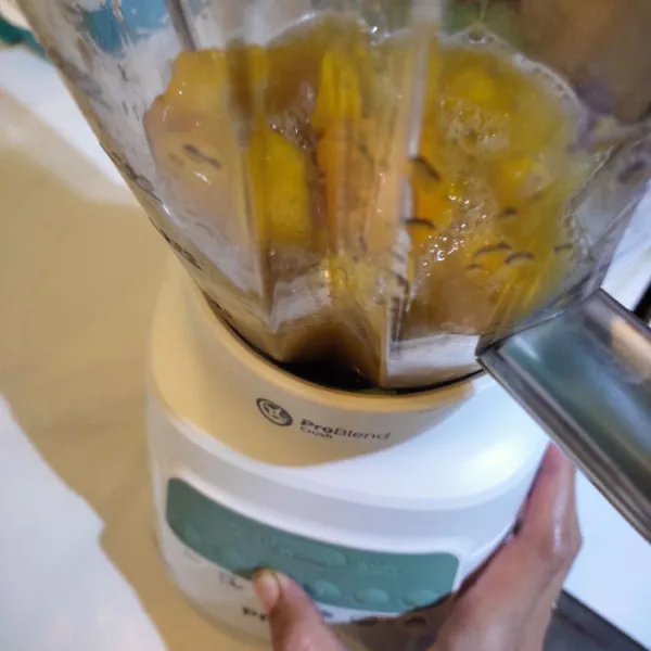 Masukkan mangga beku ke dalam gelas blender, tambahkan susu UHT, madu dan gula cair. Proses dengan blender hingga halus.