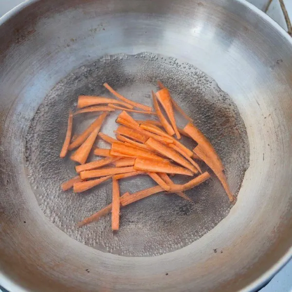 Kupas kulit wortel, kemudian potong korek api. Lalu rebus hingga empuk, tiriskan.