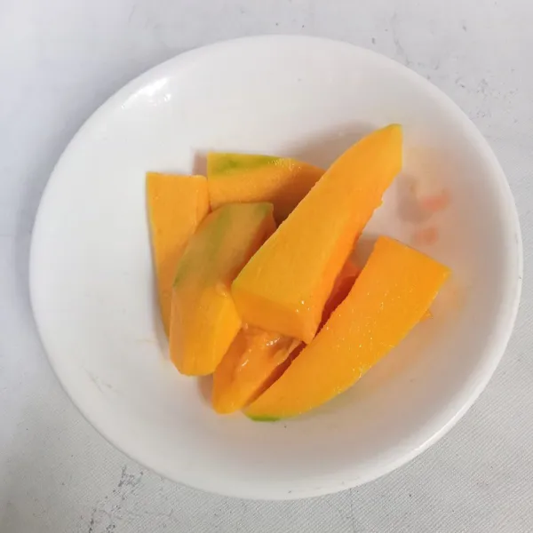 Kupas mangga dan potong-potong.