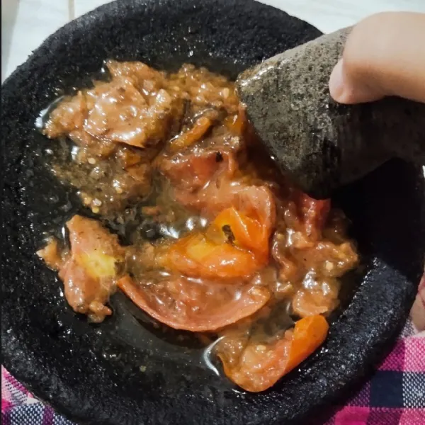 Goreng tomat dan terasi hingga layu, kemudian masukkan kedalam cobek ulek hingga halus.