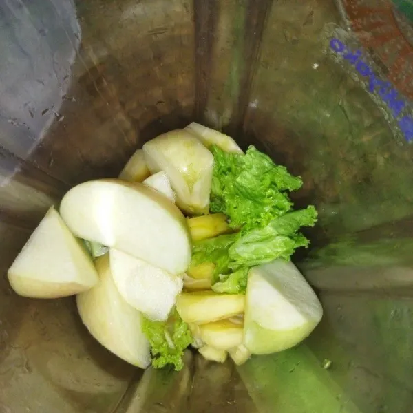 Masukkan potongan nanas, daun selada dan apel.