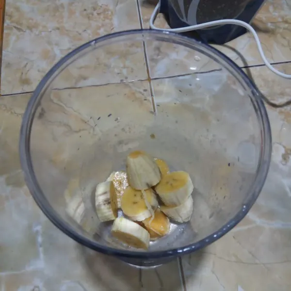 Potong-potong pisang, masukkan ke dalam gelas blender.