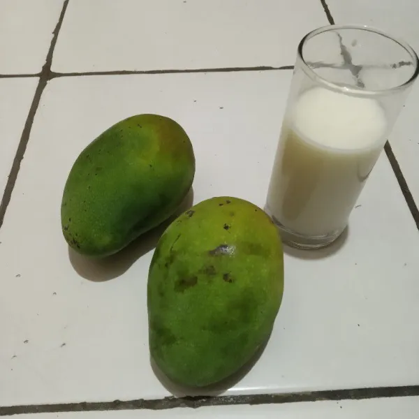 Pilih buah mangga yang manis, lalu kupas.