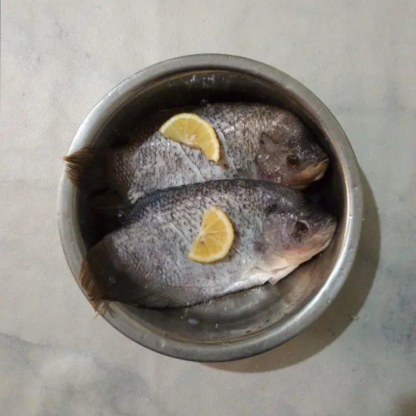 Cuci bersih ikan, lalu beri garam dan air perasan jeruk lemon. Diamkan 15 menit, bilas kembali.