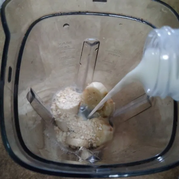 Kemudian kupas kulit pisang, iris kecil lalu masukan ke dalam blender bersama oat, madu dan yoghurt.
