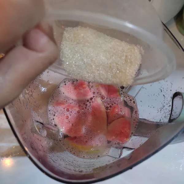 Masukkan jambu ke dalam gelas blender, tambahkan gula pasir, susu UHT, madu dan es batu.