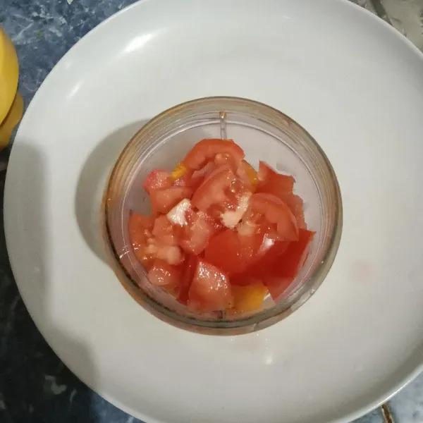 Masukkan es batu, mangga dan tomat ke dalam blender.