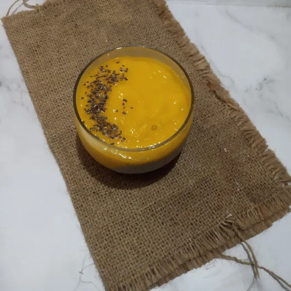 Tuang pure mangga ke gelas saji, taburi chia seed.