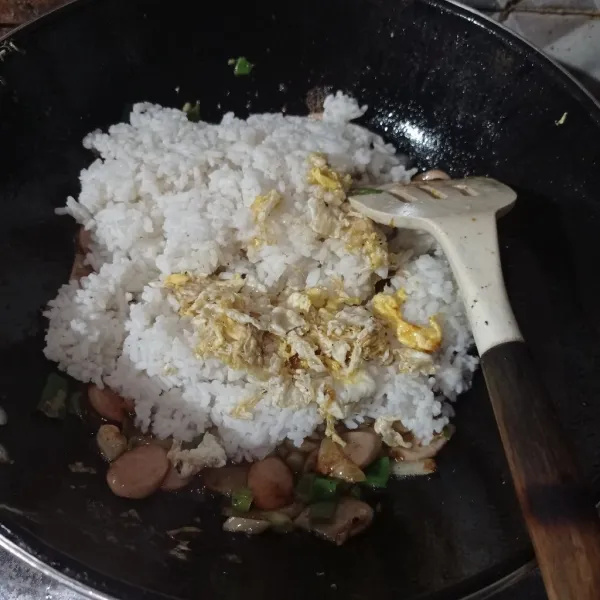 Masukan nasi, telur orak arik, kaldu bubuk dan lada bubuk aduk sampai tercampur rata.