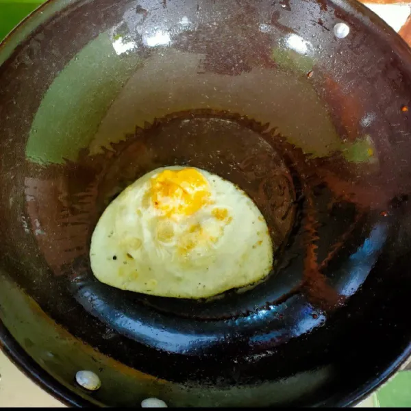 Siapkan wajan lalu beri minyak goreng laLu ceplok telur dan beri garam sedikit. Goreng sampai matang.