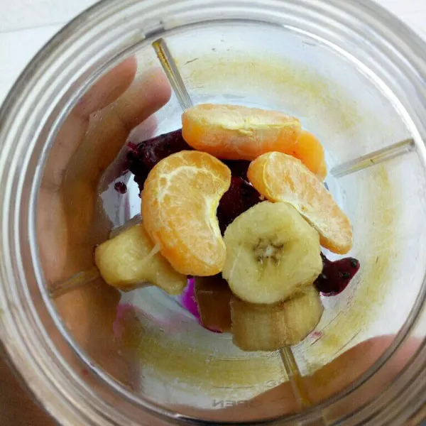 Siapkan blender, masukan buah naga, pisang, dan jeruk yang sudah beku.