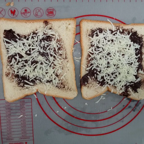 Olesi roti dengan cokelat pasta tambahkan taburan keju diatasnya.