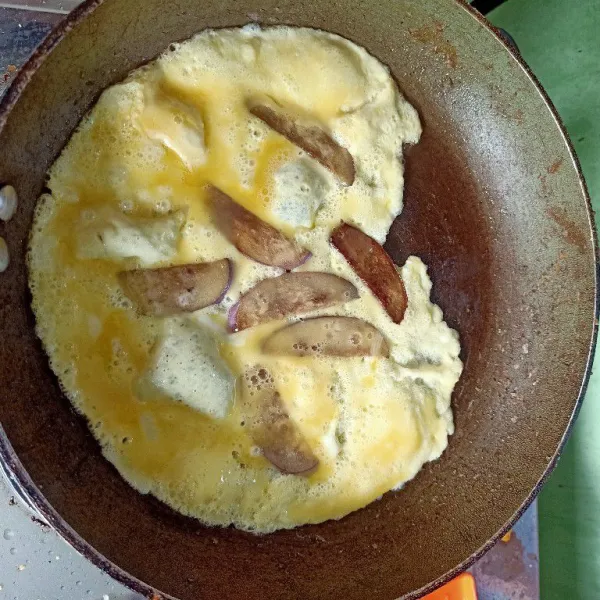 Buat dadar telur terong. Balikkan sisi lainnya jika matang. Lalu angkat dan sajikan kedalam piring, sertakan dengan nasi matang dan cabe rawit/ cengek.