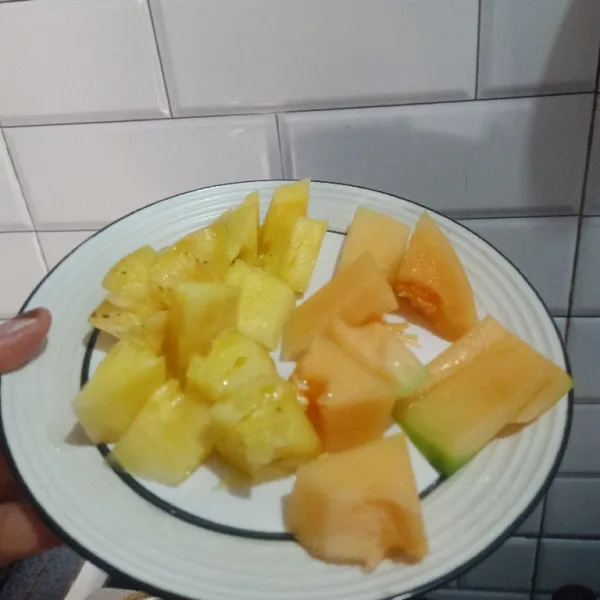 Kupas melon dan nanas lalu potong.
