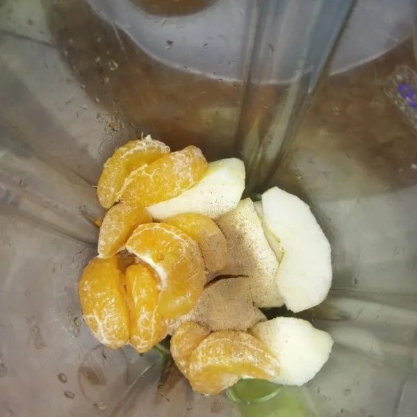 Masukkan potongan apel ke dalam blender, masukkan jeruk yang sudah dikupas, dibuang bijinya dan bagian putih jeruk, tambahkan juga kayu manis bubuk.