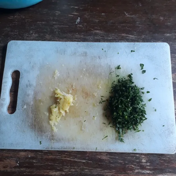 Ulek bawang putih hingga halus dan cincang seledri.