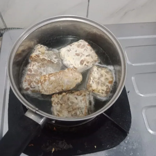 Rebus 5 menit tempe, masak di air mendidih, lalu tiriskan.