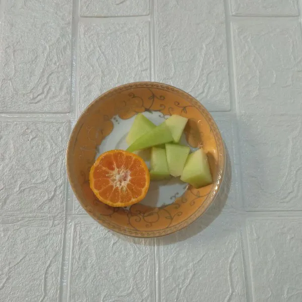 Potong-potong melon, kemudian jeruk diperas.