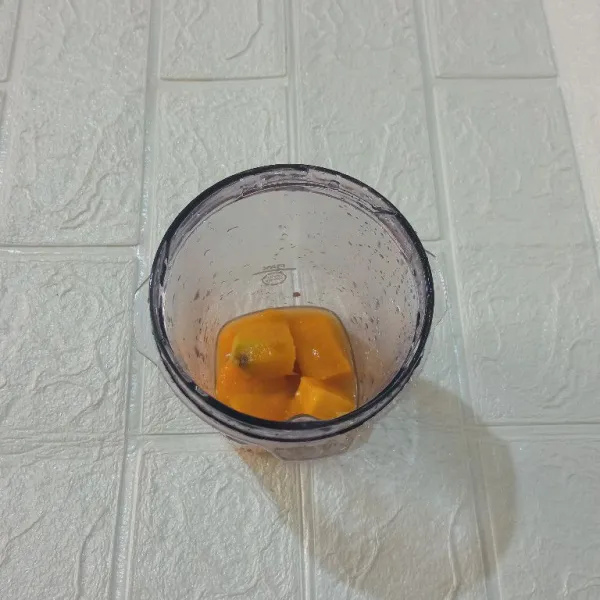 Masukkan potongan mangga dan air jeruk  ke dalam blender.