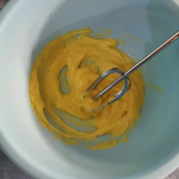 Campur margarin dan susu kental manis dalam wadah, aduk hingga rata menggunakan whisk.