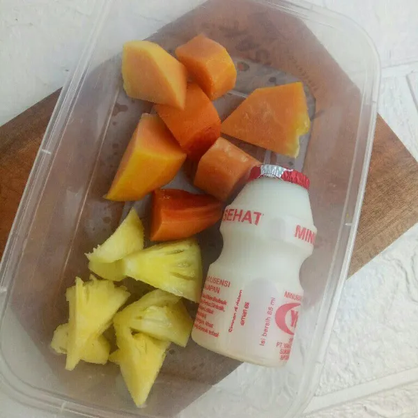 Siapkan buah pepaya dan nanas. Potong menjadi beberapa bagian.