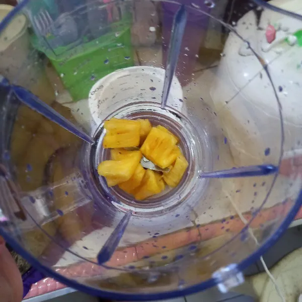 Masukkan nanas ke dalam wadah blender.