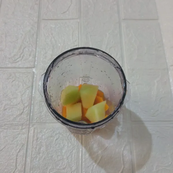 Masukkan melon, mangga dan air jeruk ke dalam blender.