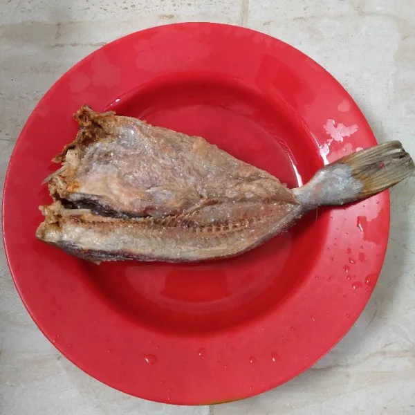 Cuci bersih ikan asin, beri perasan jeruk nipis, diamkan kurang lebih 5-10 menit, siram dengan air panas