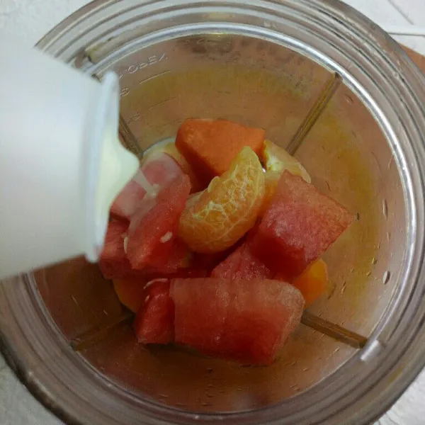 Siapkan blender, masukkan buah pepaya, semangka dan jeruk. Kemudian masukkan minuman probiotik.