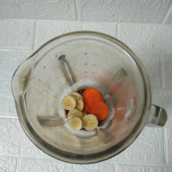 Masukkan pisang dan wortel yang sudah dipotong ke dalam blender.