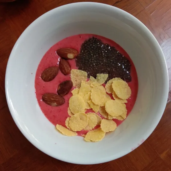 Tuang ke dalam mangkuk. Beri topping chia seed, corn flakes dan almond utuh.