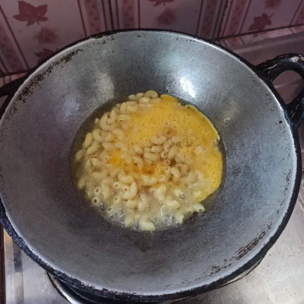 Panaskan minyak goreng secukupnya, masukkan makaroni kemudian tuang telur.