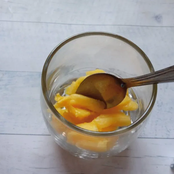 Tuang nanas ke gelas tambahkan sirup gula.