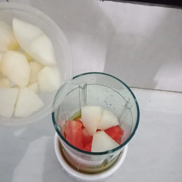 Masukkan buah semangka dan pir yang sudah dipotong-potong ke dalam blender.