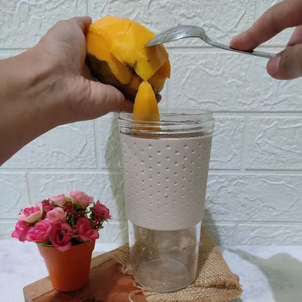 Masukkan potongan buah mangga ke dalam blender.