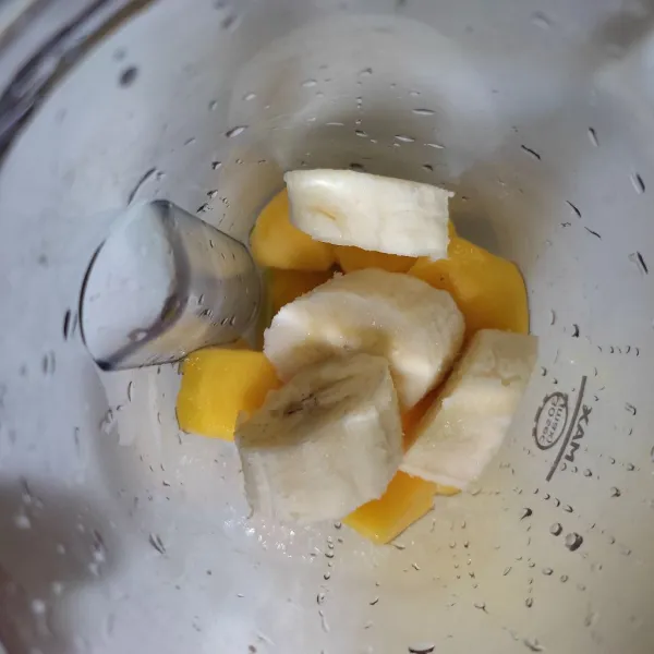 Masukkan mangga, pisang dan yogurt ke dalam gelas blender.