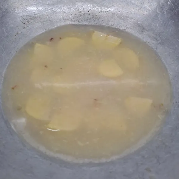 Masukkan kentang dan air, masak sampai mendidih dan kentang ½ matang.