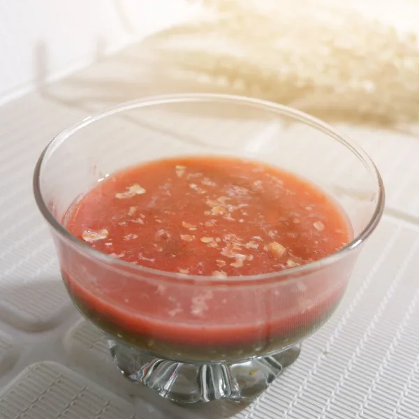 Tuang bayam smoothie ke gelas lalu tuang perlahan lapisan strawberry di atasnya.