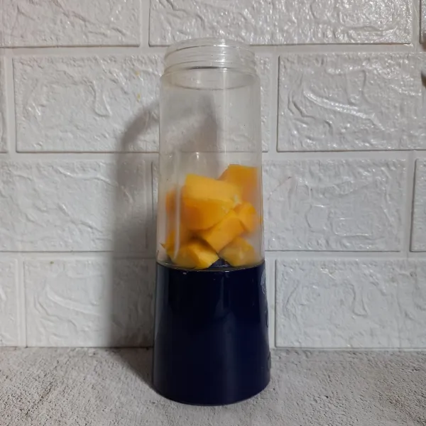 Masukkan buah mangga ke dalam blender.