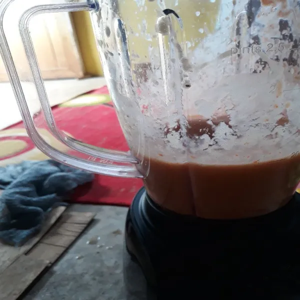 Masukkan wortel, mangga dan tomat dalam blender. Beri es batu serta susu cair.