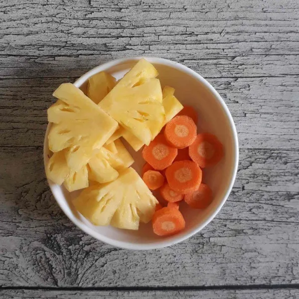 Kupas dan bersihkan buah nanas dan wortel lalu potong-potong.