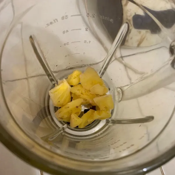 Masukkan potongan buah nanas ke dalam blender.