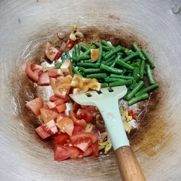 Masukkan kacang panjang dan tomat, aduk rata. Tuang air, masak sampai kacang setengah matang.