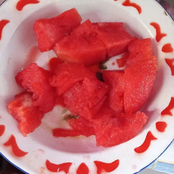 Potong-potong buah semangka dan buang bijinya.