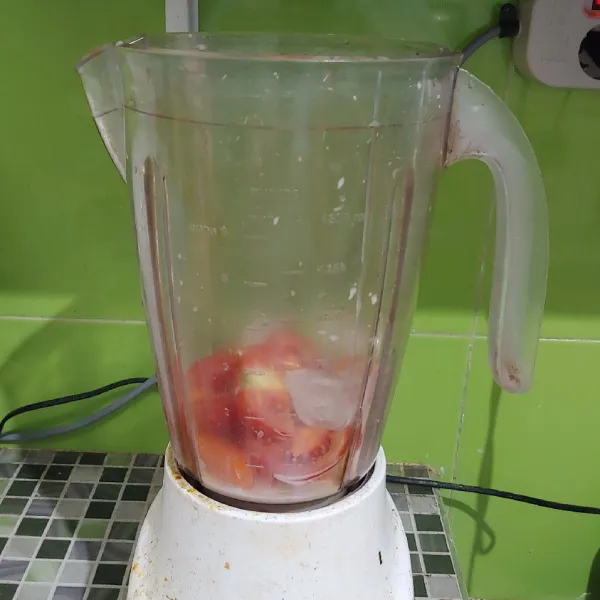 Masukkan ke dalam blender tomat dan wortel lalu masukkan es cube dan susu uht.